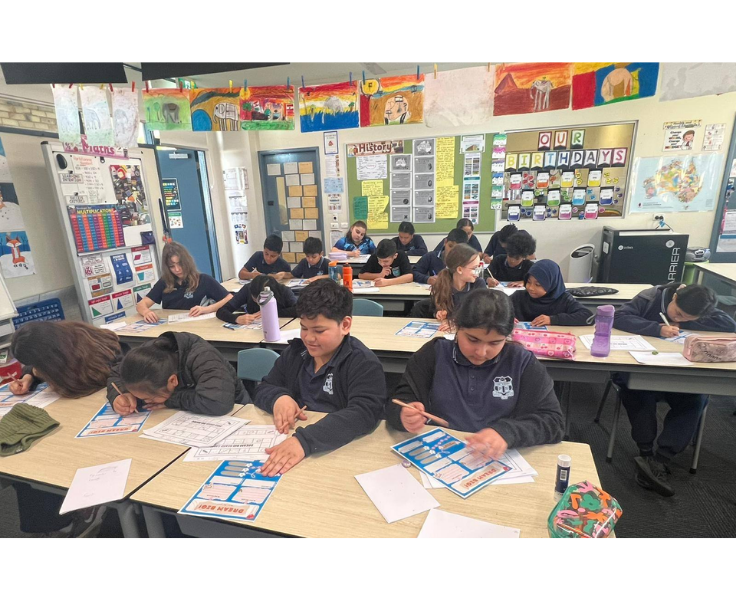 Students are working at their desks in a lively and well-decorated classroom, contributing to a bright and comfortable learning environment.